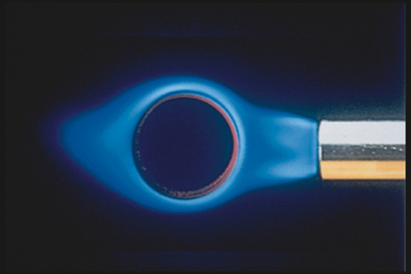 En R!MAC CYKLONMUNSTYCKE delvis sedd från höger håller på att värmas upp, med en blå låga som omger den i en mörk bakgrund.