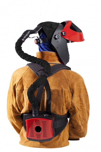 Person i skyddsutrustning, inklusive en WELTEK SLIP/SKÄRVISIR 5 DIN MED FRIKLUFTSENHET med en ansluten slang som leder till ett ventilationsaggregat på ryggen. Utrustningen är designad för andningsskydd i farliga miljöer.