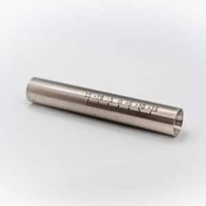 En metallisk cylindrisk Hållare till laserpistol MaxPhotonics med graverade numeriska markeringar och linjer, från -15 till 15, vilar på en vit yta.